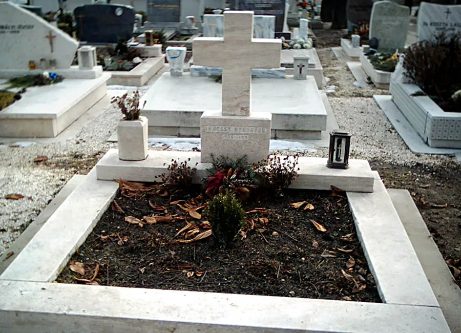 Csiszolt fehér mészkő dupla sírkő kereszttel és ágyással, temetőben elhelyezve