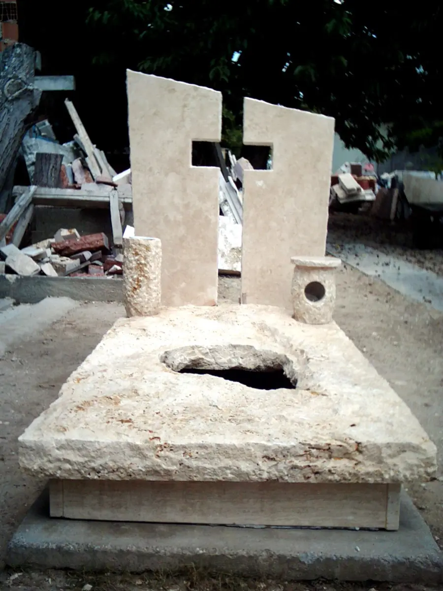 Két egyedi mészkő fejkő kivágott kereszt mintával, műhelyben készítés közben